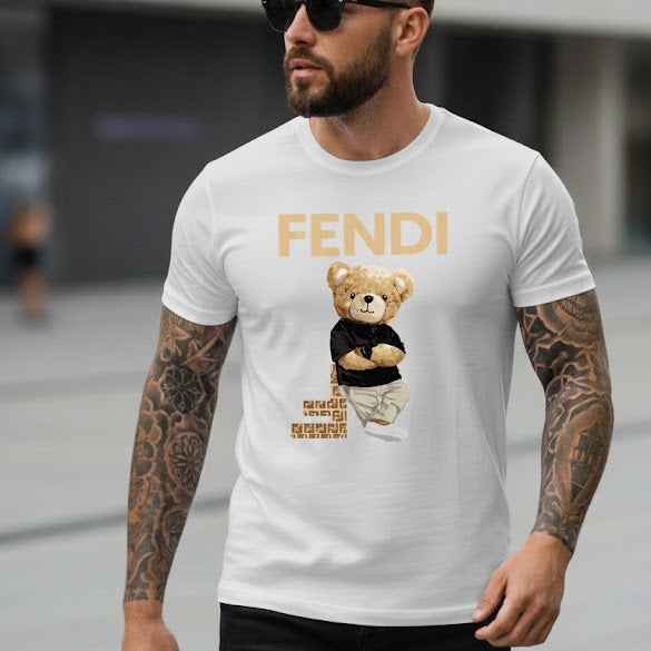 Мъж с черни очила и татуировки, облечен в бяла тениска с надпис Fendi и принт на мече, съчетана с черни панталони.