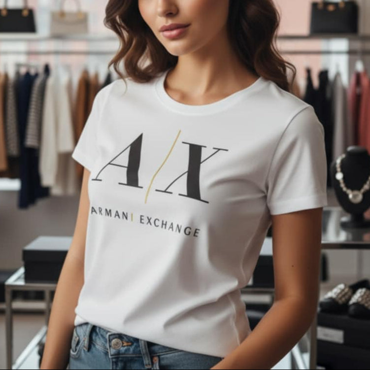 Млада жена, носеща бяла тениска Armani Exchange с голямо черно лого A|X и златиста линия, в магазинна обстановка.