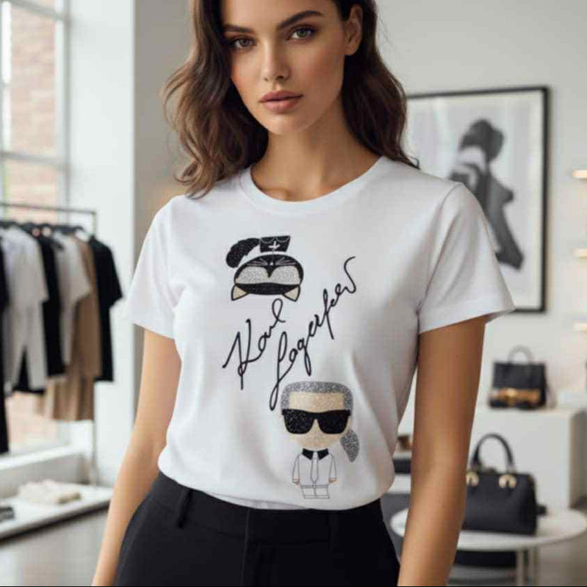 Дамска бяла тениска Karl Lagerfeld с графика на Карл Лагерфелд и котката Шупет, декорирани с черни и сребристи блестящи елементи, заснета в бутик.