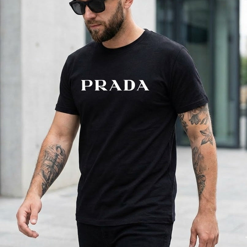 Мъж с черна тениска Prada с изчистен бял надпис на гърдите и слънчеви очила